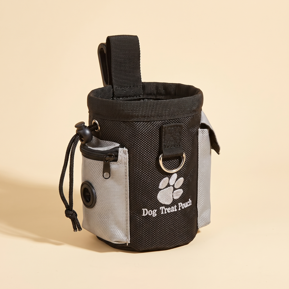 Black and grey clip-on dog treat pouch with paw print on a plain cream background