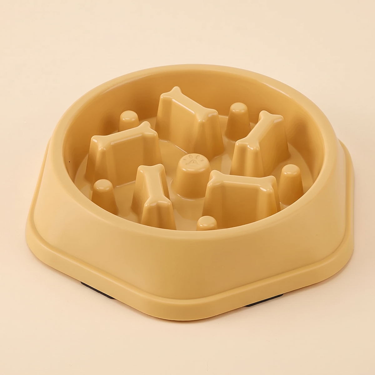 Yellow non slip slow feeder dog bowl on a plain cream background