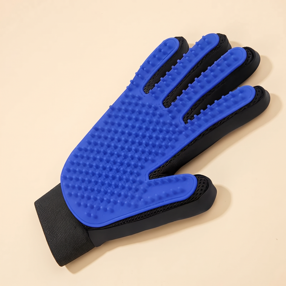Blue silicone deshedding pet grooming glove on a cream background