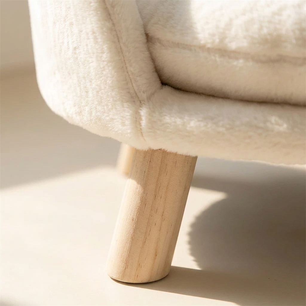 Close detail of the curved plush shell meeting a tapered pale wooden leg