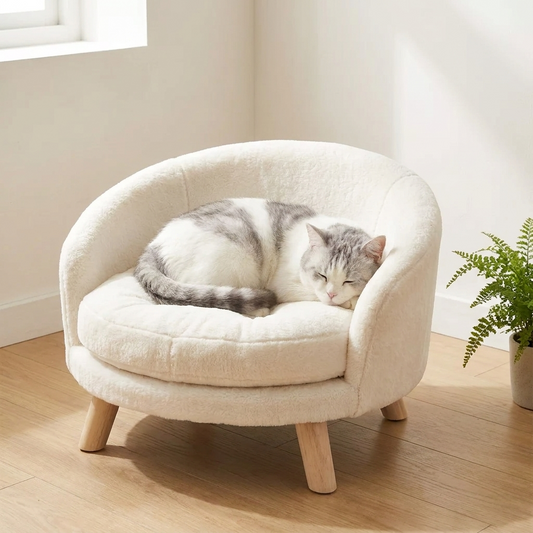 Grey and white cat curled inside the cream plush nesting chair bed