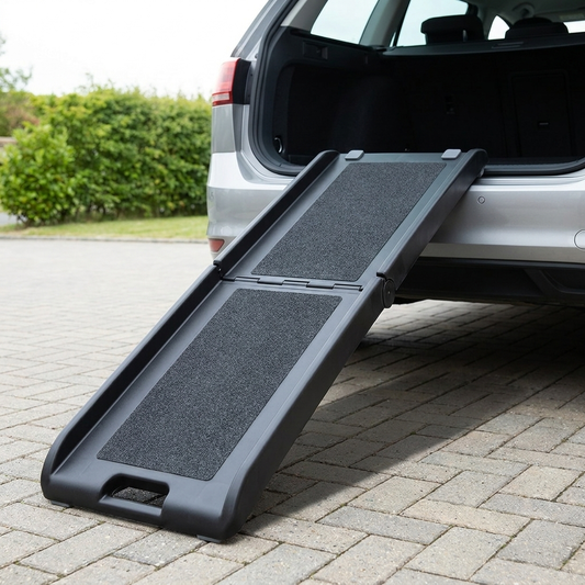 Folding black dog car ramp set up from an estate car boot onto a block paved driveway