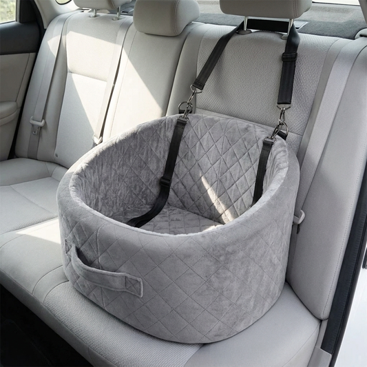Grey quilted pet car booster seat strapped to the rear seat of a car