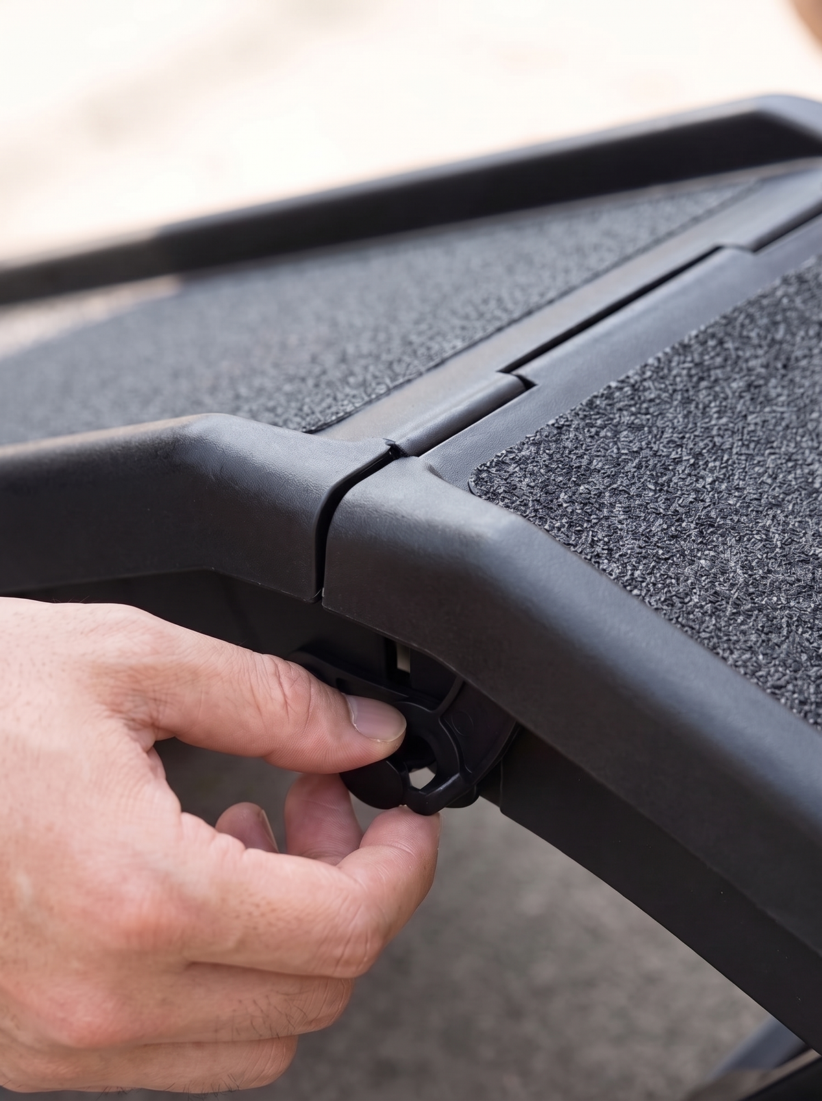 Close detail of the carry handle at the end of the folded dog car ramp