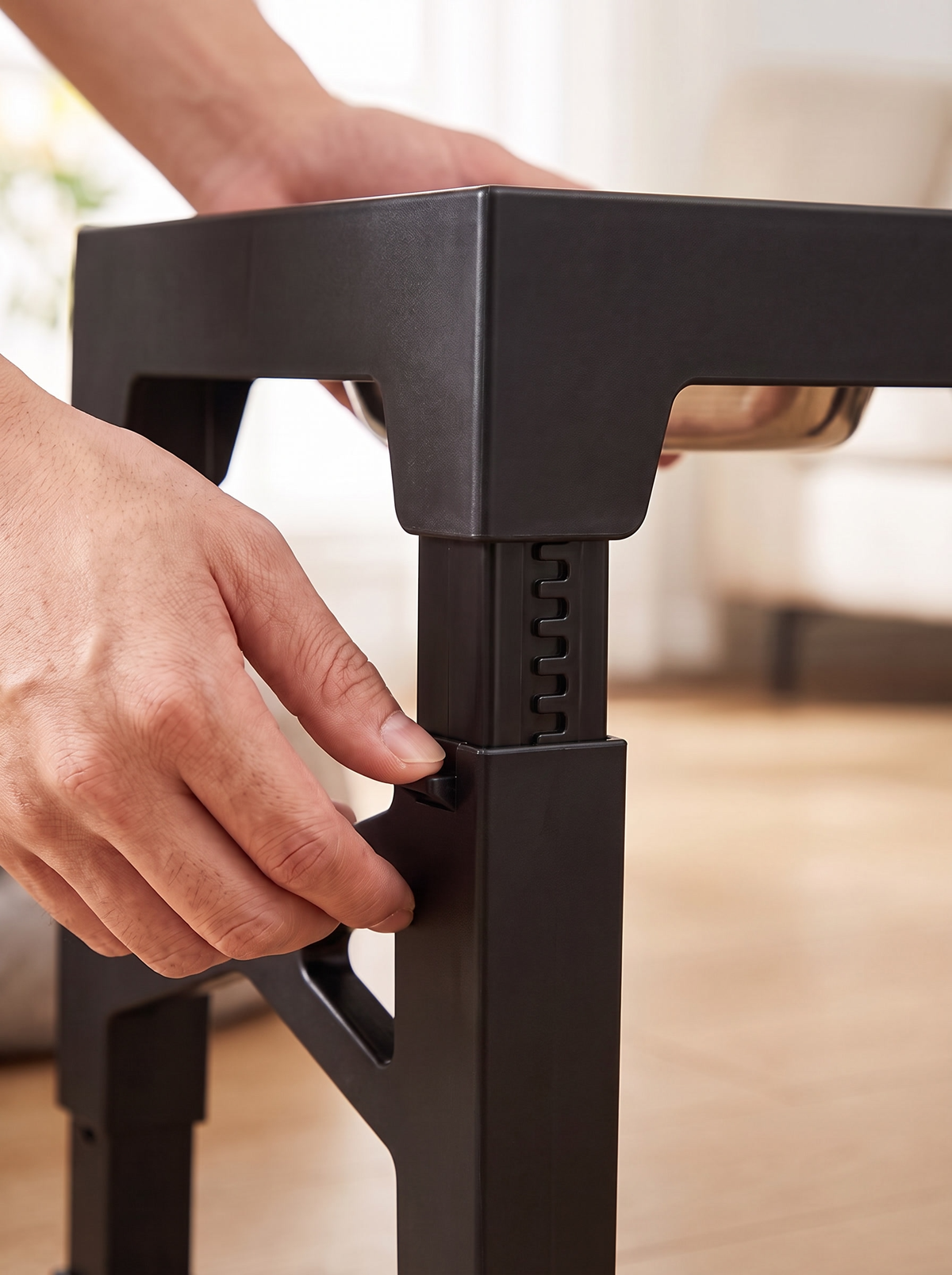 Close detail of the telescopic leg being adjusted to a new height notch