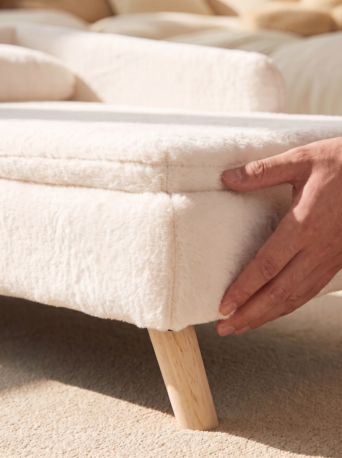 Close detail of the removable cream plush cover being lifted from the stool bed frame