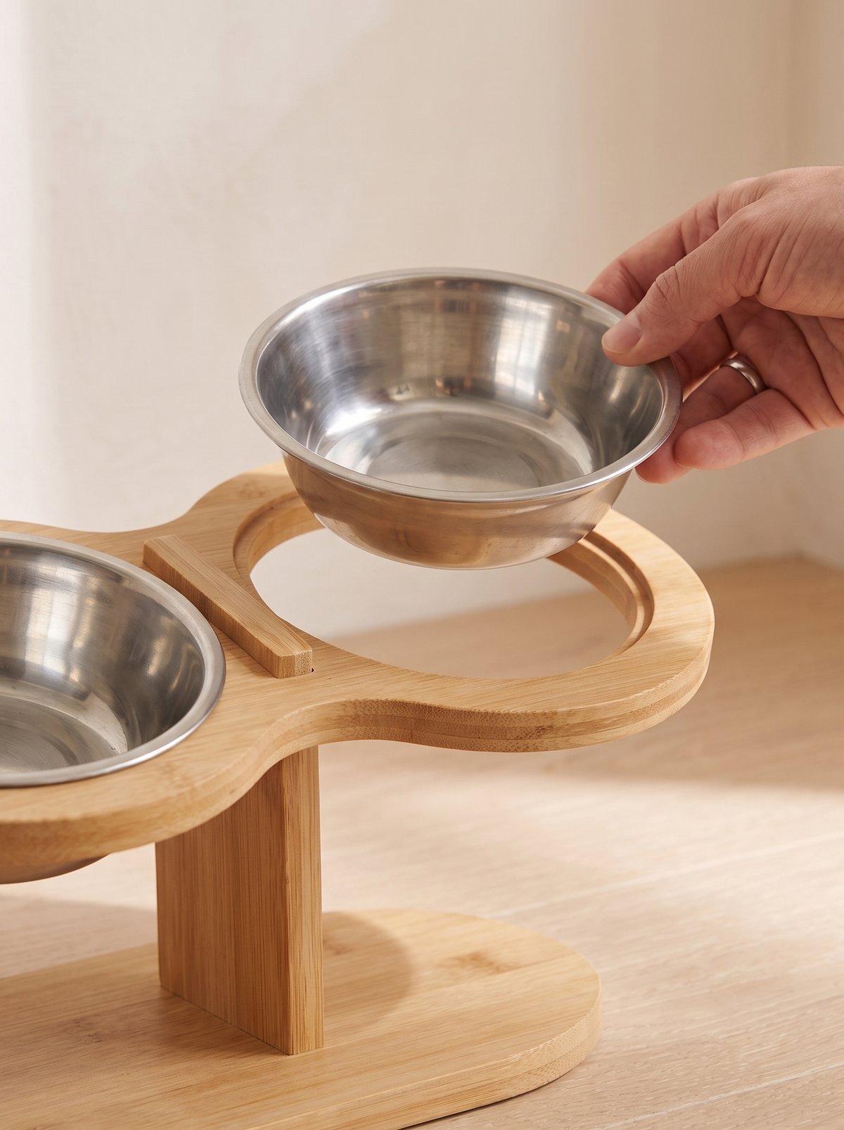 Close detail of a stainless steel bowl lifted out of the bamboo deck for washing