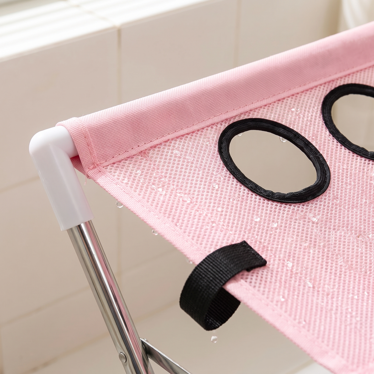Close-up of the pink quick-dry mesh, black-edged leg opening and webbing loop on the dog bath hammock stand