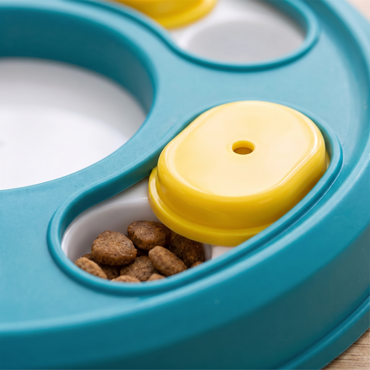 Close-up of a yellow slider half open over kibble on the dog puzzle feeder