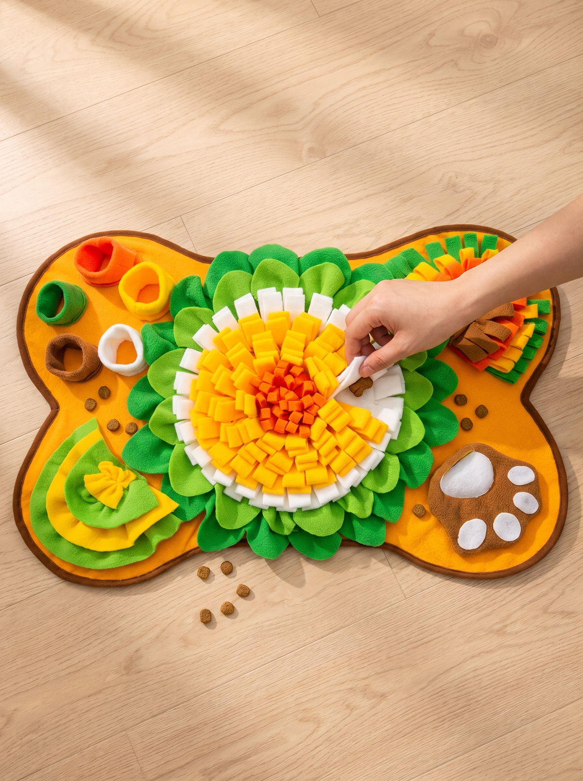 Hand tucking a dog treat under a fleece petal of the snuffle mat