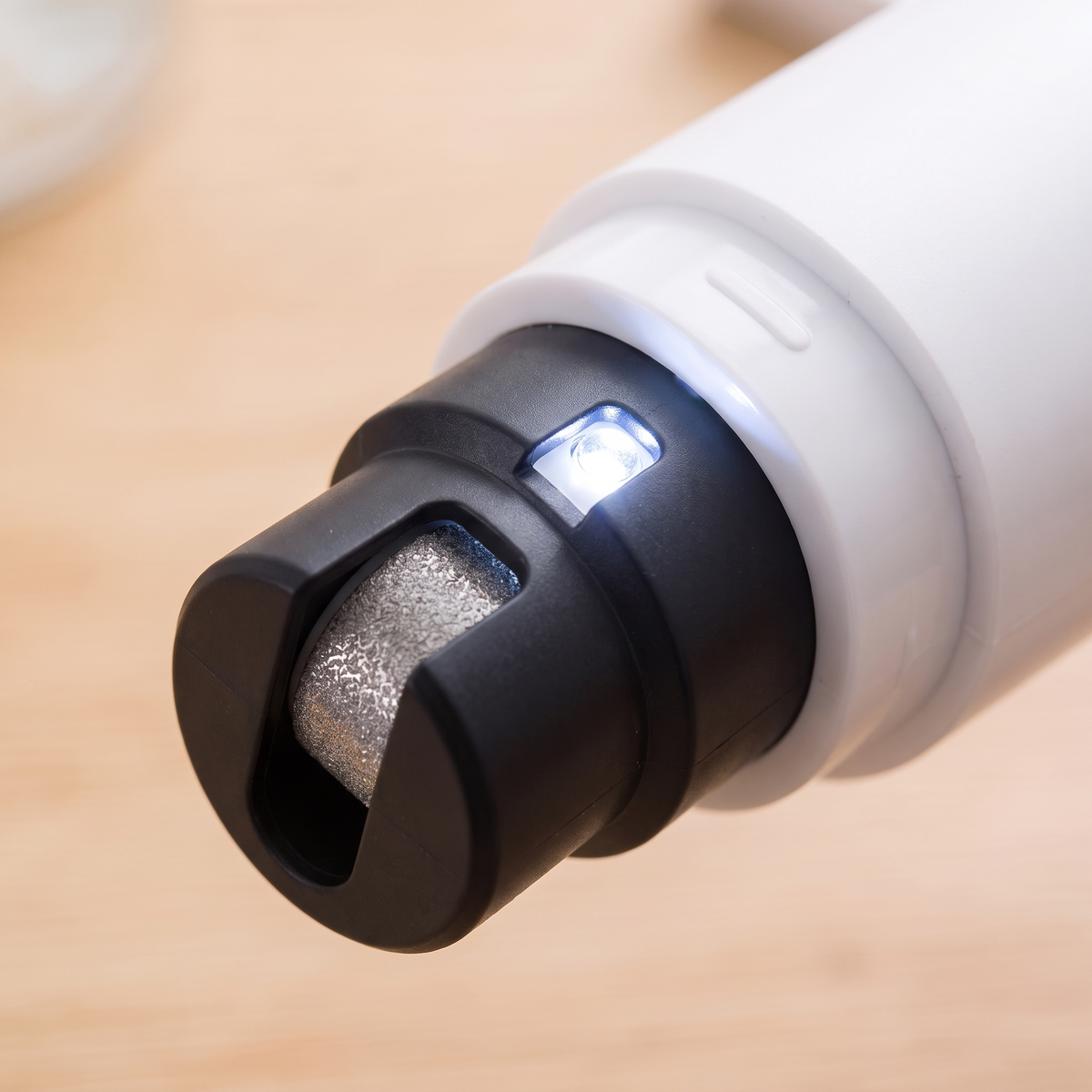 Close-up of the black grinding head, diamond wheel and built-in LED light on the dog nail grinder