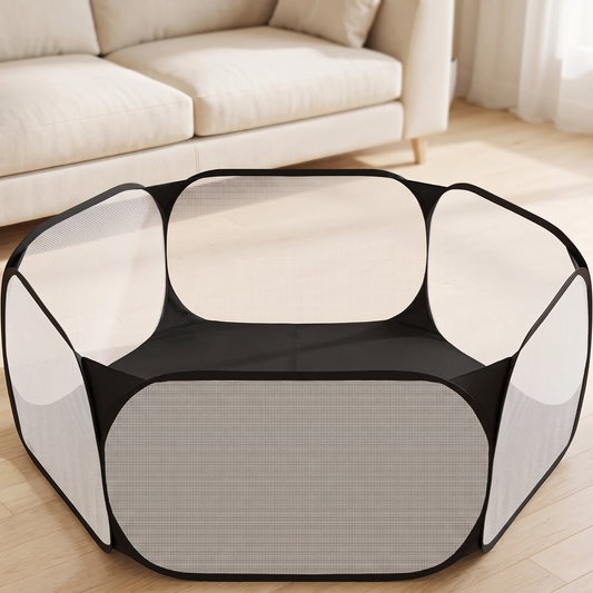 Black hexagonal pop up pet playpen with white mesh panels on a living room floor
