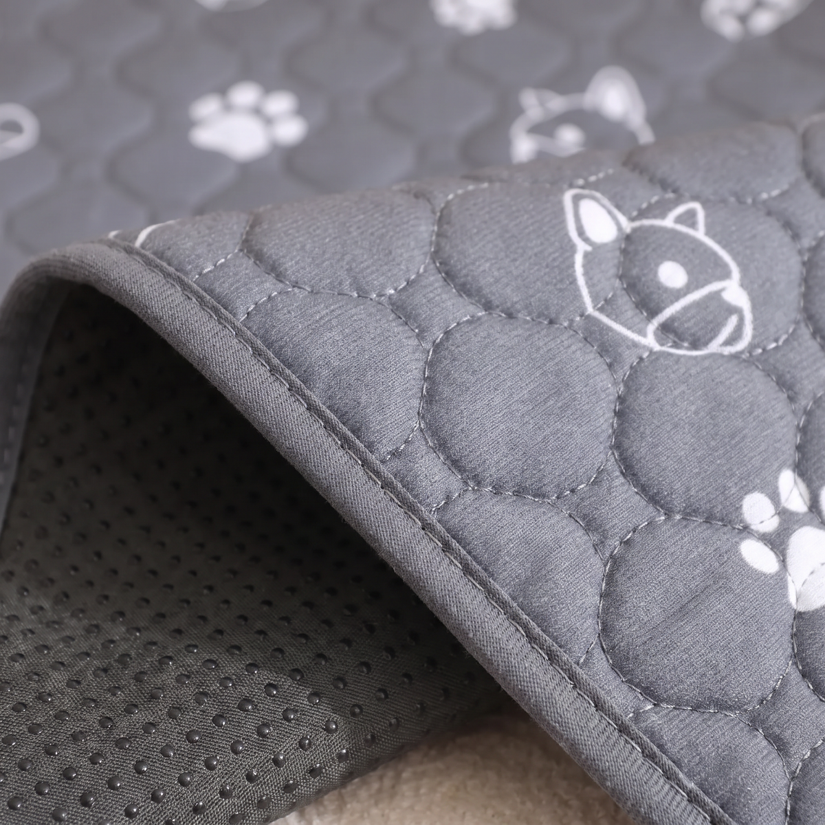Close-up of the quilted top, bound edge and dotted grip backing of the washable puppy pad