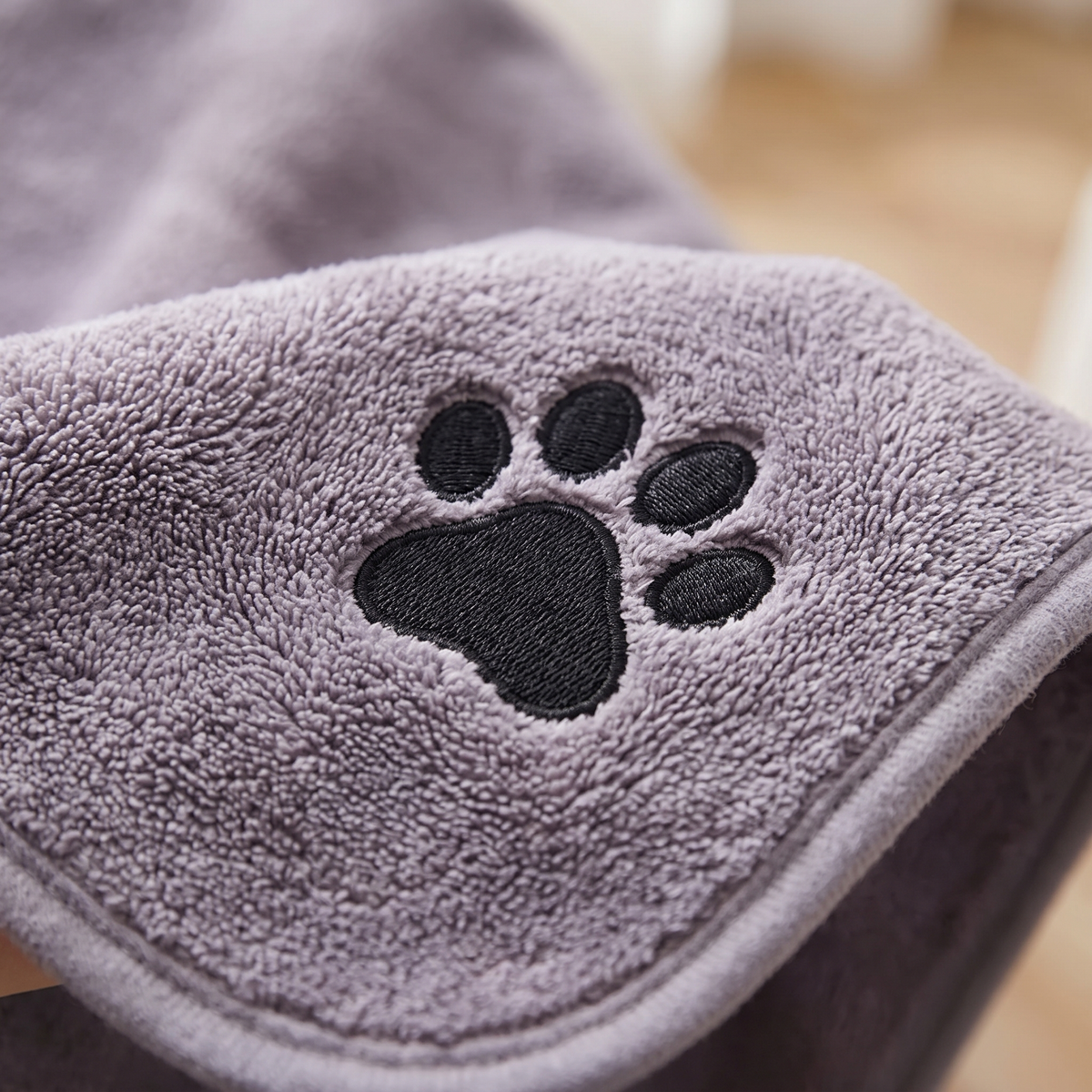 Close-up of the embroidered paw and soft pile on a microfibre dog towel