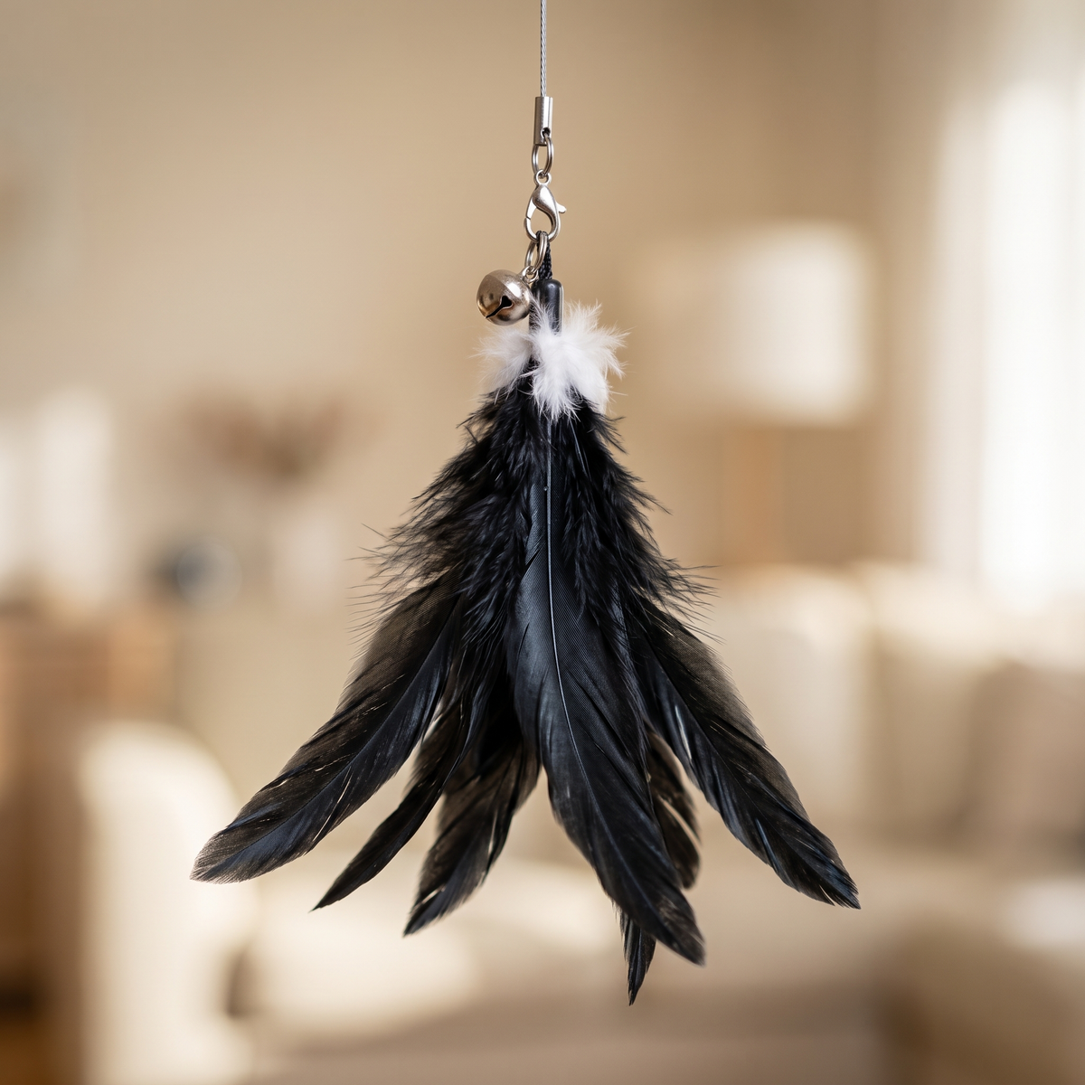 Close-up of the black feathers and bell on a cat teaser wand