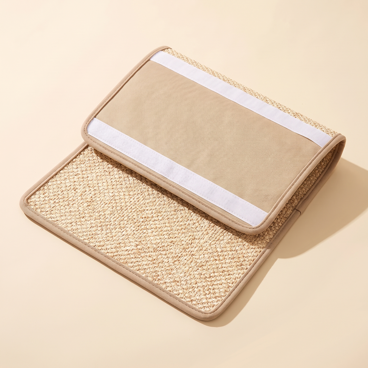 Sisal cat scratching mat folded back to show the white hook-and-loop fixing strips on its reverse