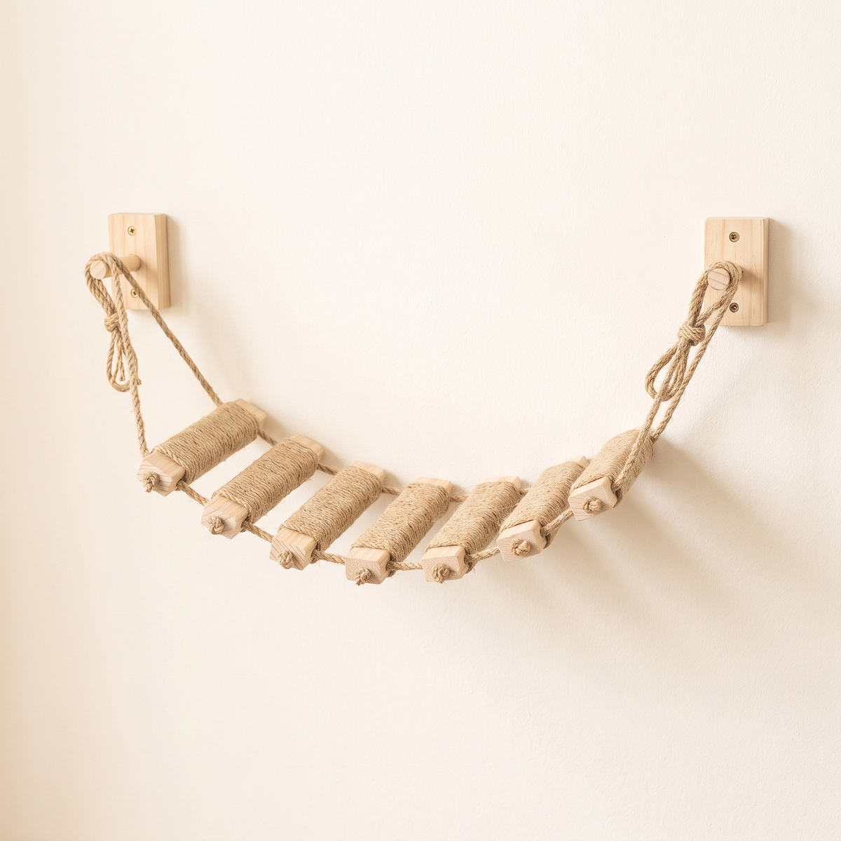 Front view of a sisal cat rope bridge with jute side ropes and knotted loops on two wall blocks