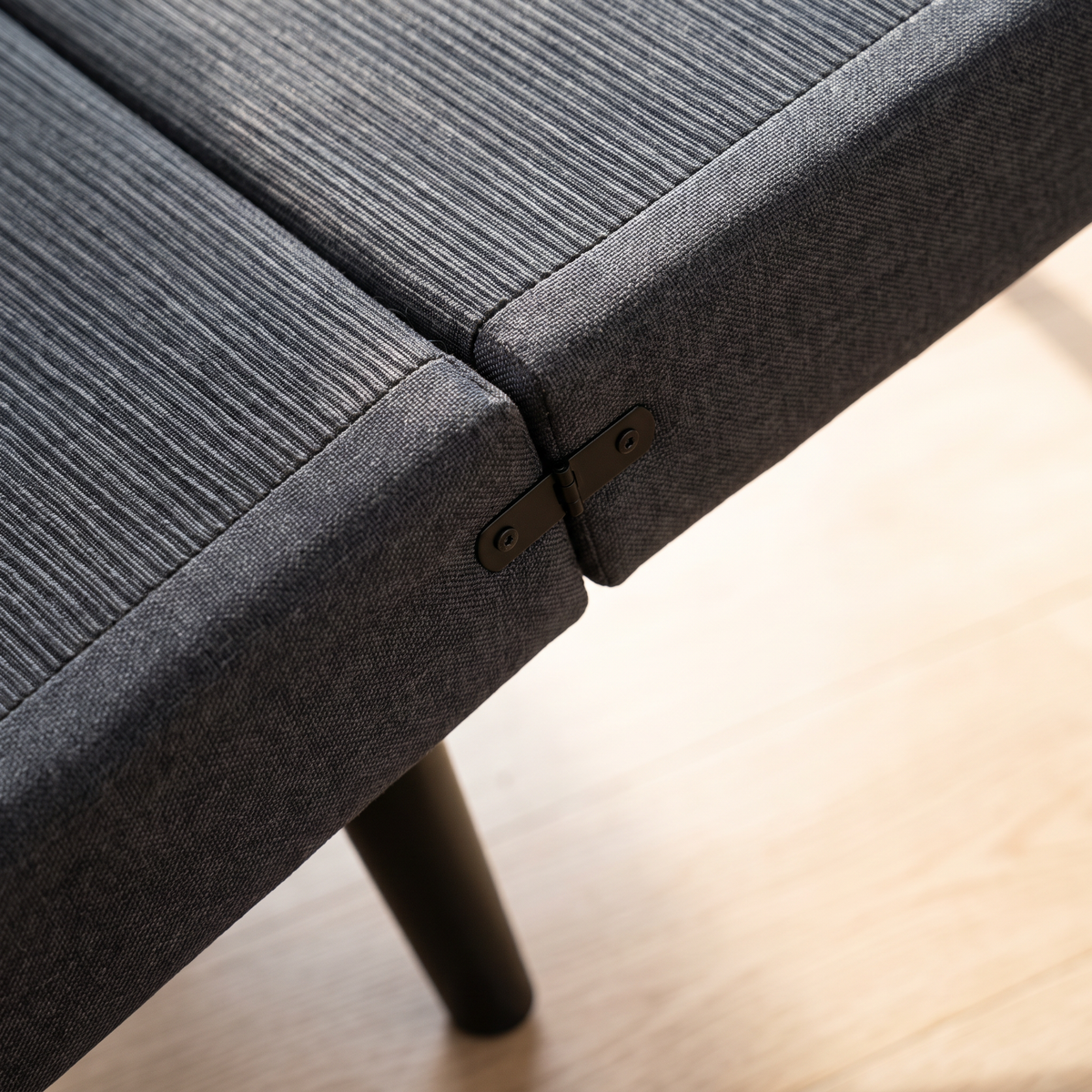 Close-up of the ribbed non-slip deck and metal hinge on a charcoal dog ramp